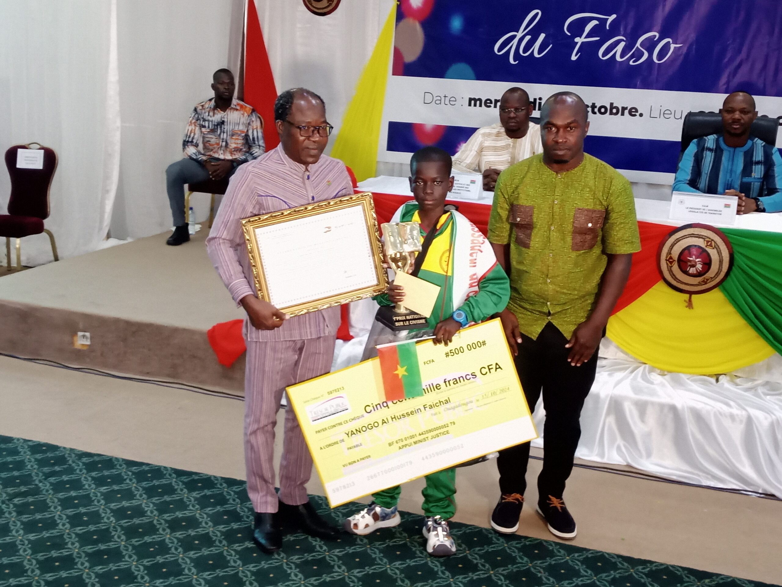 Le premier prix national du jeu concours civisme en milieu scolaire, Faichal Yanogo, recevant sa récompense, 16 octobre 2024