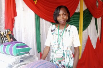 La présidente de l'Association coiffure solidaire du Boukiemdé (ACS/BLK), Véronique Roamba présente son stand à la Galerie marchande du FESPACO 2025